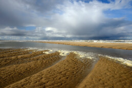 Als het zeewater zich terug trekt ontstaan er mooie vormen in het zand langs de achtergebleven zwinnen | © Ronald van Wijk Fotografie