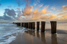 Op het strand bij De Kerf liggen een aantal mooie, fotogenieke strekdammen met houten palen | © Ronald van Wijk Fotografie